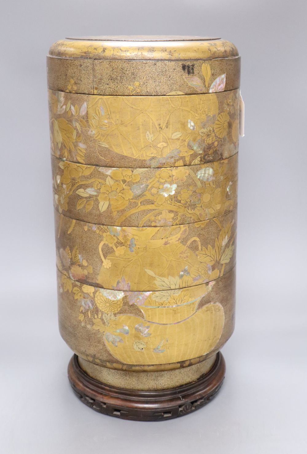 A 19th century Japanese sectional stack of mother of pearl and lacquered boxes, on hardwood stand, overall height 46cm
